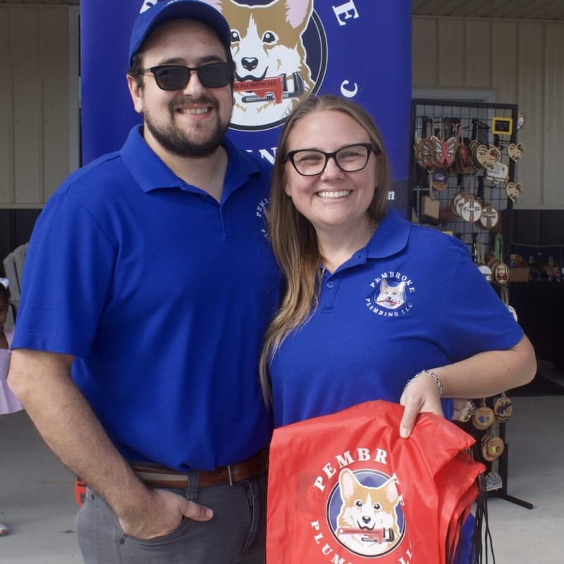 Man and woman in blue company shirts holding a branded bag