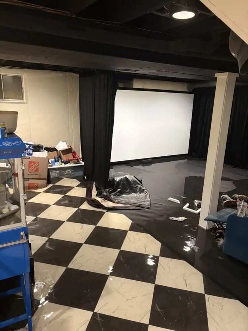 Basement with checkered floor and wet surfaces, projector screen